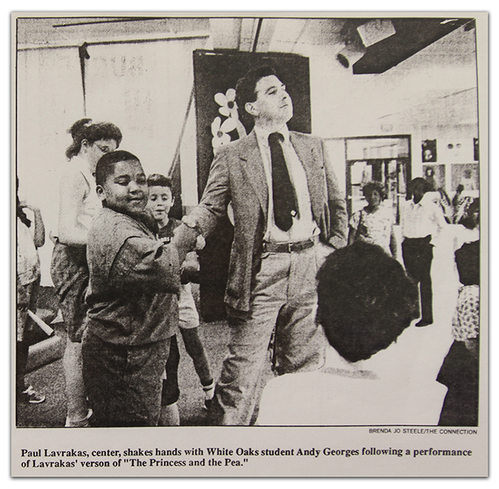 Black and white photograph from a newspaper article showing Paul Lavarakas shaking hands with White Oaks students.