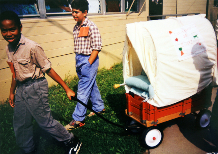 Photographs of two students pulling a Red Flyer wagon decorated to look like a Conestoga wagon.